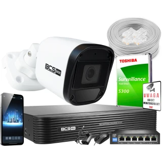 Zestaw monitoringu składający się z kamery BCS Basic, rejestratora, dysku twardego Toshiba, kabla sieciowego oraz akcesoriów montażowych. Na zdjęciu widoczny jest również smartfon z aplikacją do monitoringu oraz znak ostrzegawczy o monitorowanym obiekcie.