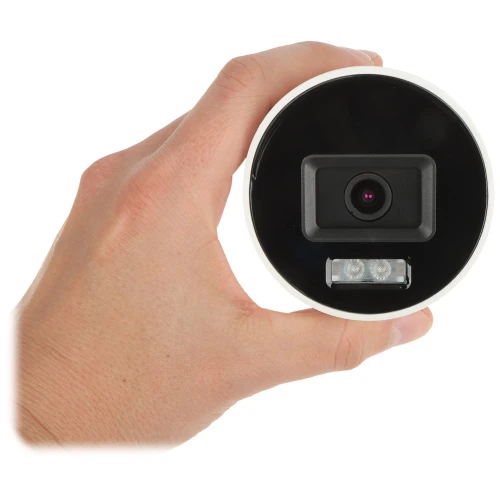 Na zdjęciu widać rękę trzymającą okrągłą kamerę z czarnym frontem i obiektywem pośrodku. Poniżej obiektywu znajdują się dwa małe światła LED.