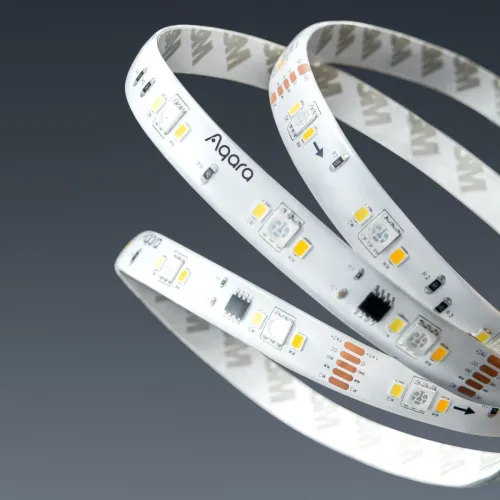 Na zdjęciu widać zwiniętą taśmę LED marki Aqara z widocznymi diodami i elementami elektronicznymi na białym tle. Taśma ma nadrukowane logo oraz oznaczenia techniczne, a w tle jest szare tło.