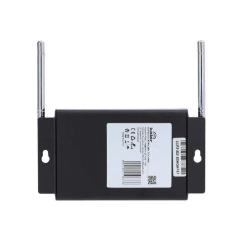 Czarny wzmacniacz sygnału z dwiema antenami po bokach i etykietą z kodem kreskowym na środku. Urządzenie ma prostokątny kształt i otwory montażowe po bokach.