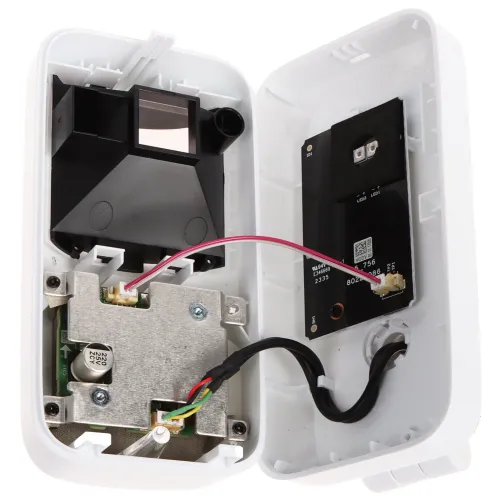 Zdjęcie przedstawia otwarte wnętrze elektronicznego urządzenia z widocznymi komponentami, takimi jak płytki drukowane i przewody. Obudowa jest biała, a elementy wewnętrzne mają różne kolory, w tym czarny, srebrny i czerwony.