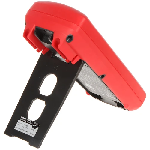 Na zdjęciu znajduje się czerwony miernik z czarną, rozkładaną podpórką, umożliwiającą ustawienie urządzenia pod kątem. Widoczna jest tylna część obudowy z etykietą informacyjną oraz otworami na podpórce.