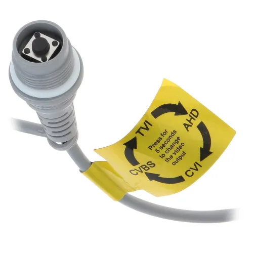 Zbliżenie na szary kabel z przyciskiem i żółtą etykietą informującą o zmianie standardu sygnału wideo. Etykieta pokazuje opcje: TVI, AHD, CVI, CVBS.